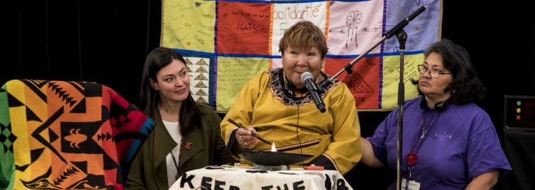 Commissioner Qajaq Robinson, left, and Barbara Sevigny, right, look on during the lighting of the qulliq by Elder Rebecca Veevee at the Knowledge Keepers and Expert Hearing on a Human Rights Framework in Quebec City in May 2018.